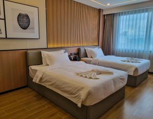 a hotel room with two beds with towels on them at Man tony hotel in North Pattaya