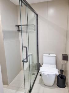 a bathroom with a toilet and a glass shower at Man tony hotel in North Pattaya +13 photos