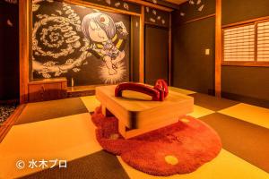 a room with a red rug and a wooden box at Ooedo Onsen Monogatari Kaike in Yonago