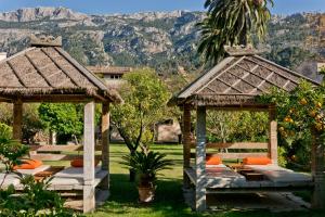 two gazebos in a garden with mountains in the background at Hotel Can Roses in Sóller