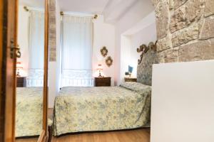 1 dormitorio con 2 camas y espejo en La piazzetta delle erbe, en Asís