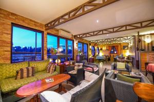 a living room with couches and tables and windows at San Art Floating Hostel & Apartments in Belgrade
