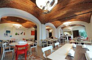 a restaurant with wooden ceilings and tables and chairs at The Ziba Hotel & Spa in Peschiera del Garda