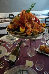 a plate of seafood on a table with a bottle of wine at Logis Hôtel Les Chardons Bleus RESTAURANT LE BISTROT DE LA MER in Roscoff