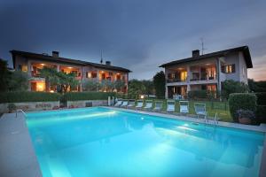 a large swimming pool in front of a house at Corte degli Olivi Appartamenti in Manerba del Garda