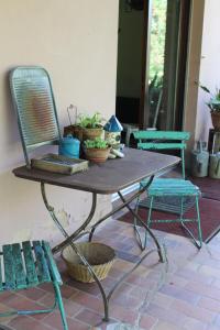 une table avec une chaise et des plantes sur une terrasse dans l'établissement Dans le Jardin de Marie, à Bouxwiller