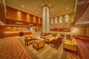 a lobby with couches and chairs in a hospital at Ooedo Onsen Monogatari Dogo in Matsuyama