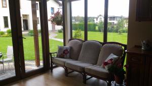 a living room with a couch in front of sliding glass doors at Holiday Home Medus in Babīte