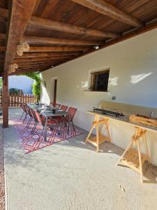 a patio with a table and chairs under a roof at Au pré des pierres in Sancé