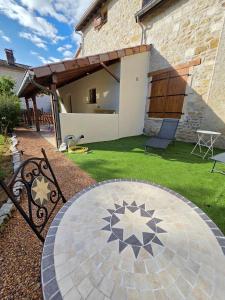 a patio with a table in a yard at Au pré des pierres in Sancé