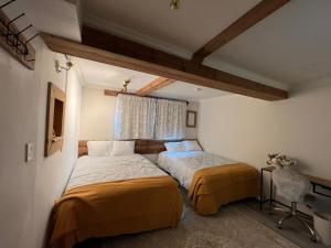 twee bedden in een kleine kamer met een raam bij Carlton House in Toronto