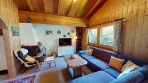 a living room with a blue couch and a table at Nicole in Blatten bei Naters