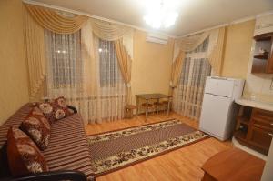 een woonkamer met een bank en een koelkast bij VIP apartments on Admiralskaya in Nikolayev