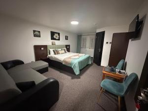 a hotel room with a bed and a couch at Vila Orizont Straja in Straja
