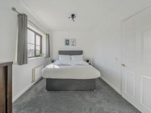 a bed in a white room with a window at Pass the Keys Large Family Home Parking - Oxford in Oxford