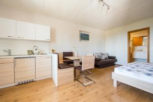 eine Küche und ein Wohnzimmer mit einem Tisch und einem Sofa in der Unterkunft Haus Allmer in Stubenberg