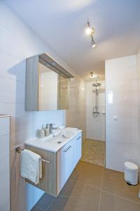 a white bathroom with a sink and a shower at Haus Allmer in Stubenberg