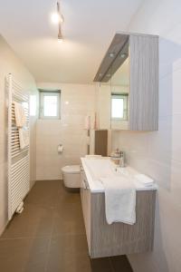 Baño blanco con lavabo y aseo en Haus Allmer, en Stubenberg