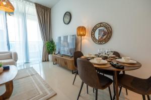 a living room with a table and chairs and a clock at Al Reem Island Pearl 1BR Retreat in Abu Dhabi +31 photos