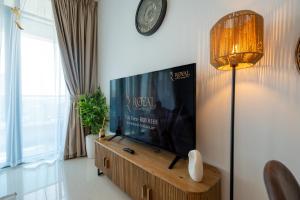 a living room with a tv and a clock on the wall at Al Reem Island Pearl 1BR Retreat in Abu Dhabi