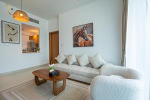 a living room with a white couch and a table at Al Reem Island Pearl 1BR Retreat in Abu Dhabi