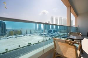 a balcony with a table and chairs and a large window at Al Reem Island Pearl 1BR Retreat in Abu Dhabi