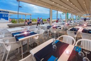 un restaurante en la playa con mesas y sillas en 4R Miramar Calafell, en Calafell