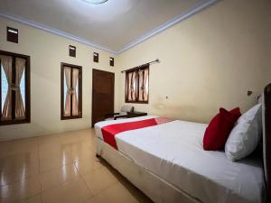 En eller flere senge i et værelse på OYO 93422 Villa Tirto