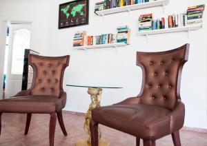 two leather chairs in a living room with a lamp at One More Day Hotel in Turgutreis