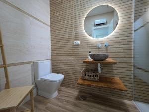 a bathroom with a sink and a toilet and a mirror at El Sagrario Apartamento céntrico con garaje gratis junto a la Catedral in Jaén +10 photos
