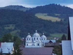 a white building with domes on top of a city at Na Wspólnej in Szlachtowa
