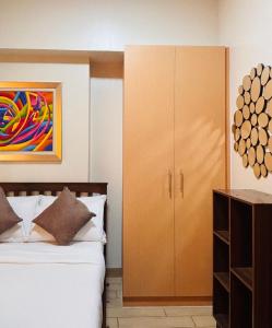a bedroom with a bed and a cabinet at Chic Minimalist Suite in Central Location in Mandurriao