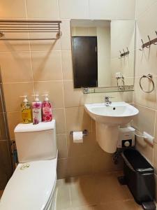a bathroom with a toilet and a sink at Chic Minimalist Suite in Central Location in Mandurriao +3 photos