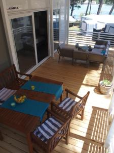 eine Terrasse mit einem Tisch und Stühlen auf einer Terrasse in der Unterkunft Luxury MobileHome Lucina Bay in Pašman