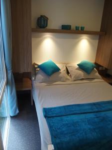 1 dormitorio con 1 cama con almohadas azules y blancas en Luxury MobileHome Lucina Bay en Pašman