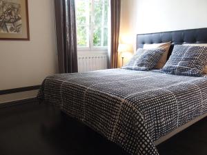 a bed with a checkered blanket and pillows on it at Bed and Breakfast Le patio in Montigny-lès-Metz