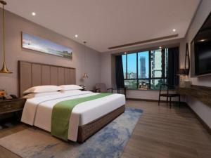 a bedroom with a large bed and a television at Landmark Hotel in Zhuhai +245 photos