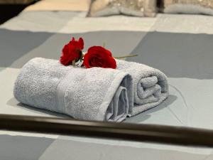 zwei rote Rosen auf einem Handtuch in der Unterkunft Royal Executive Living Garden Executive Home in Melbourne