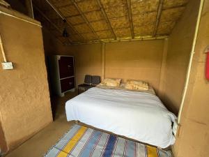 Hameri Homestay- Room 1 في ناينيتال: سرير في غرفة صغيرة بها سرير بداخلها