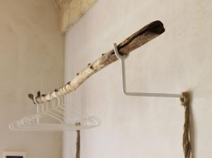 a stick hanging on a wall with a shelf at Oltre gli Ulivi in Ostuni