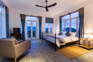 貢布的住宿－貢布精品酒店，一间卧室配有一张床、一把椅子和窗户。