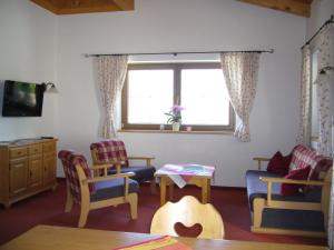 ein Wohnzimmer mit Stühlen, einem Tisch und einem Fenster in der Unterkunft Ferienwohnung Marlene in Alpbach