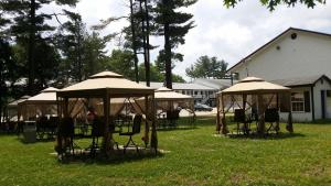 a group of tables and chairs under umbrellas in a yard at Seabrook Inn in Seabrook