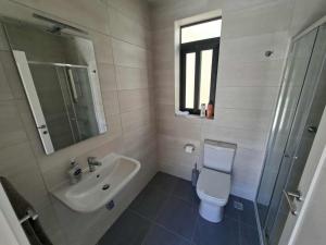 ein weißes Badezimmer mit Waschbecken und Toilette in der Unterkunft Bright Coastal Penthouse with Huge Terrace Overlooking the Sea- Ghadira Mellieha in Is-Sellum