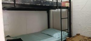 a bunk bed with a ladder and a pillow on it at Amicable Hostels in Hilongos