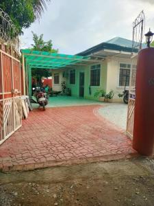 a house with a gate and a brick driveway at Amicable Hostels in Hilongos