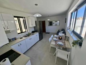 eine Küche und ein Wohnzimmer mit Tisch und Stühlen in der Unterkunft Bright Coastal Penthouse with Huge Terrace Overlooking the Sea- Ghadira Mellieha in Is-Sellum + 21 Fotos