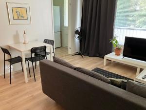 Una sala de estar con un sofá y una mesa con una computadora portátil. en Yksiö Asemakadulla, en Lapua
