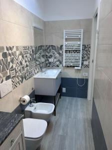 a bathroom with a sink and a toilet at Soffio di mare in San Vincenzo +7 photos