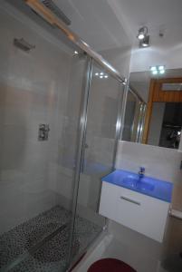 W łazience znajduje się prysznic i niebieska umywalka. w obiekcie Cromotherapy Apartment w mieście Breuil-Cervinia +9 zdjęć